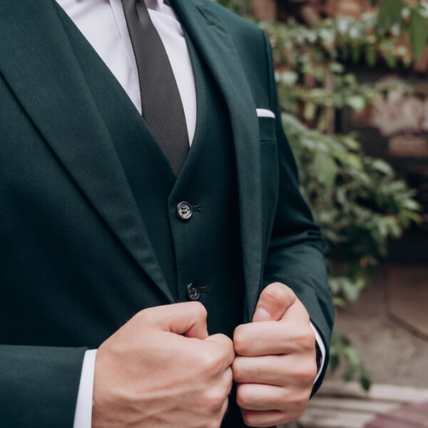 Un plan rapproché sur une sélection de tissus de costumes aux teintes élégantes et actuelles, parfaites pour inspirer le choix des couleurs d'une tenue de mariage masculine.