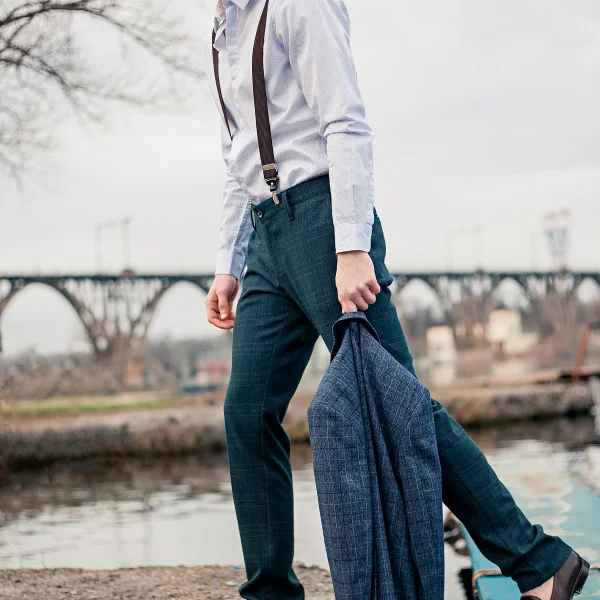 Un homme en costume, affichant un style élégant, se tient debout, représentant les nouveautés de la mode.