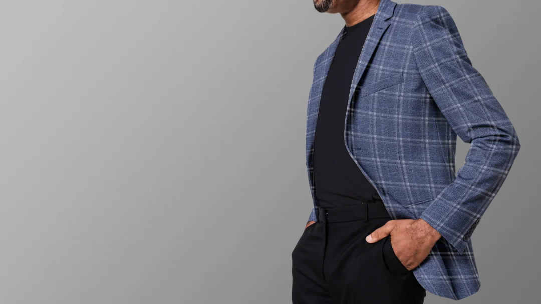 Un homme portant une veste à carreaux bleus et blancs, habillé pour une cérémonie.