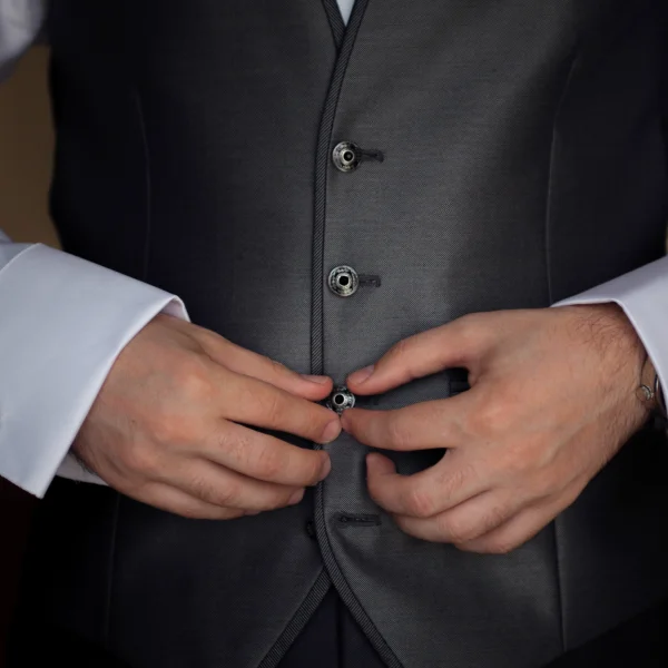 Un homme en veston, élégant, portant une tenue de cérémonie pour un événement formel.