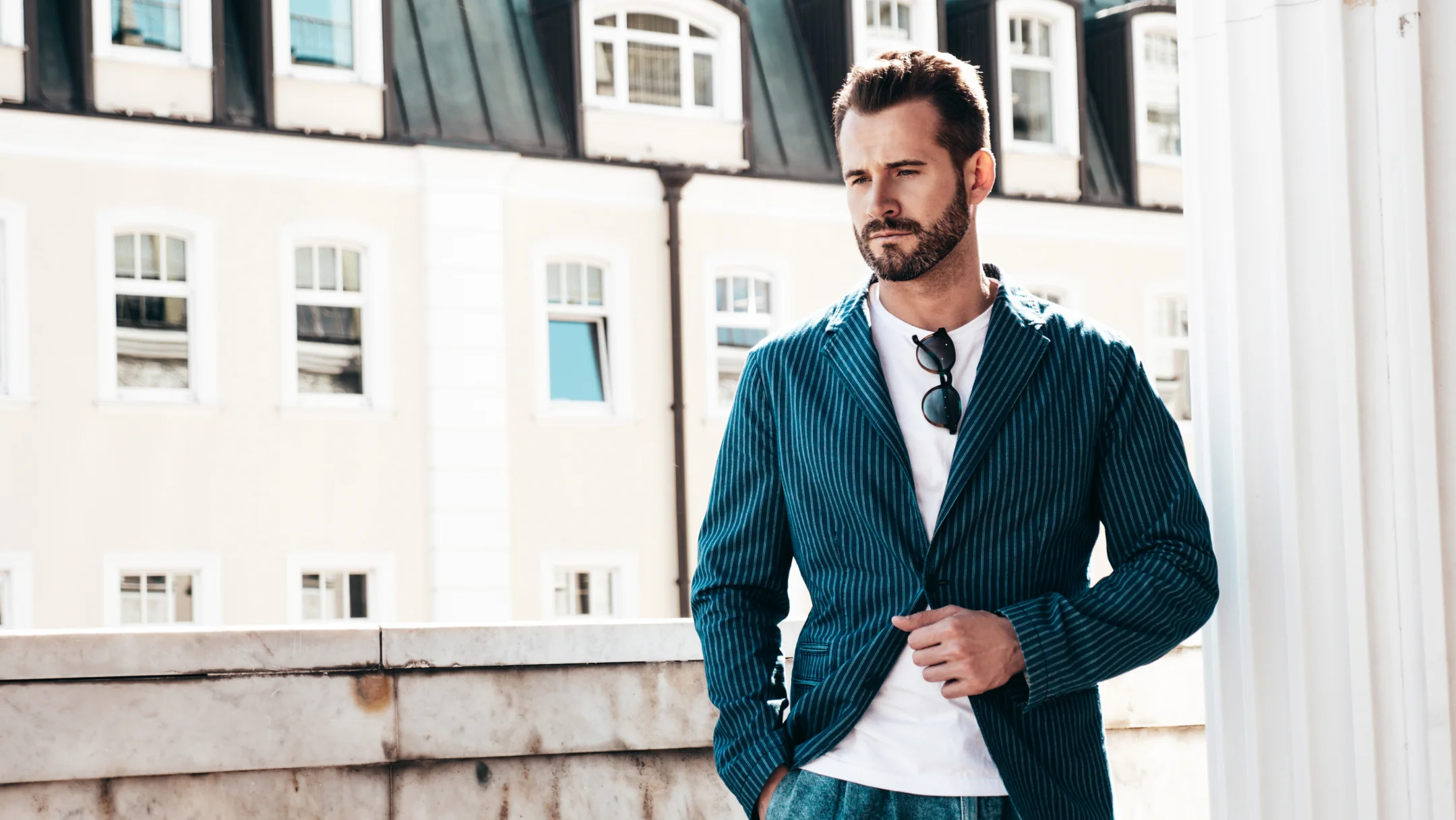 Un homme en veste bleue et chemise blanche, portant un costume italien.