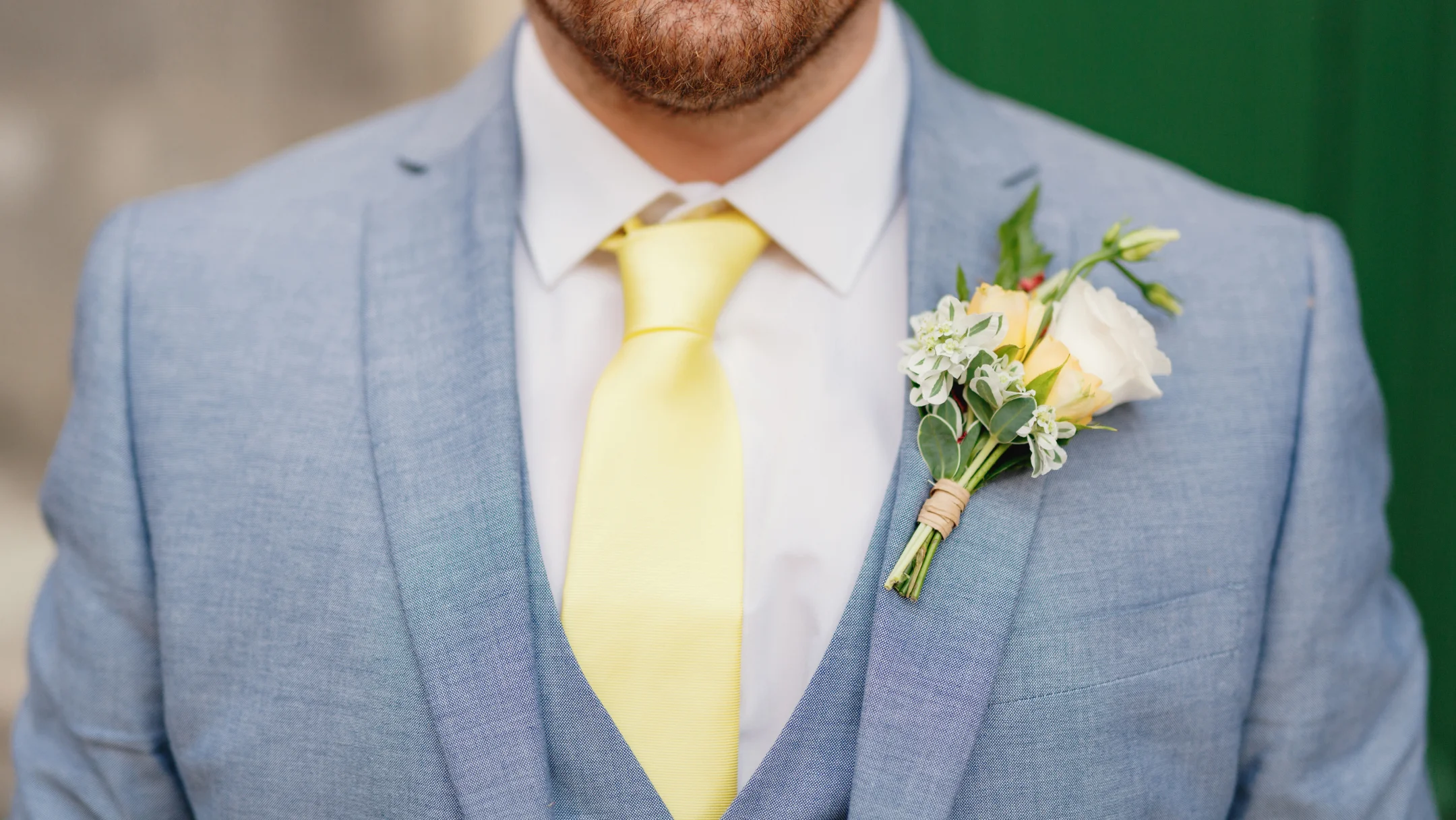 Un homme en costume avec une cravate jaune, affichant une allure élégante et professionnelle.